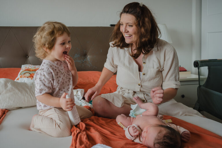 Kleinkind hilft Mama beim Wickeln – natürliche Familienfotos Graz und Umgebung, authentische Alltagsszenen