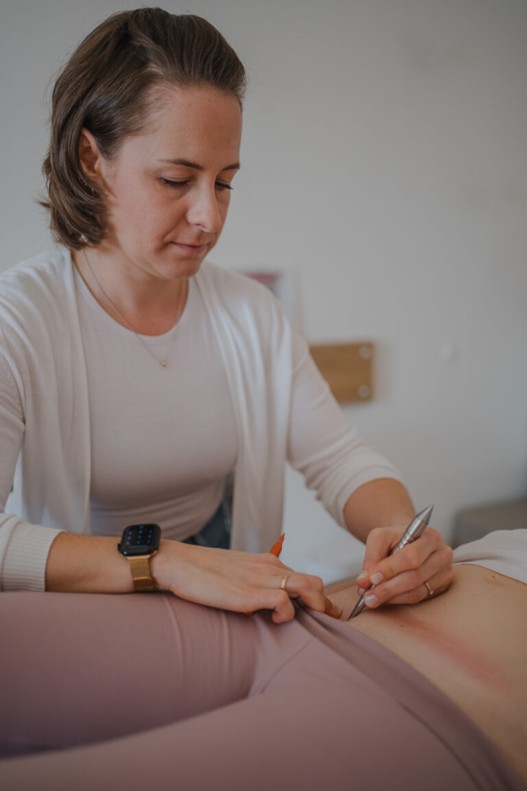 Physiotherapeutin behandelt Patientin – Businessfotografie Graz und Umgebung, authentische Arbeitsmomente in der Praxis