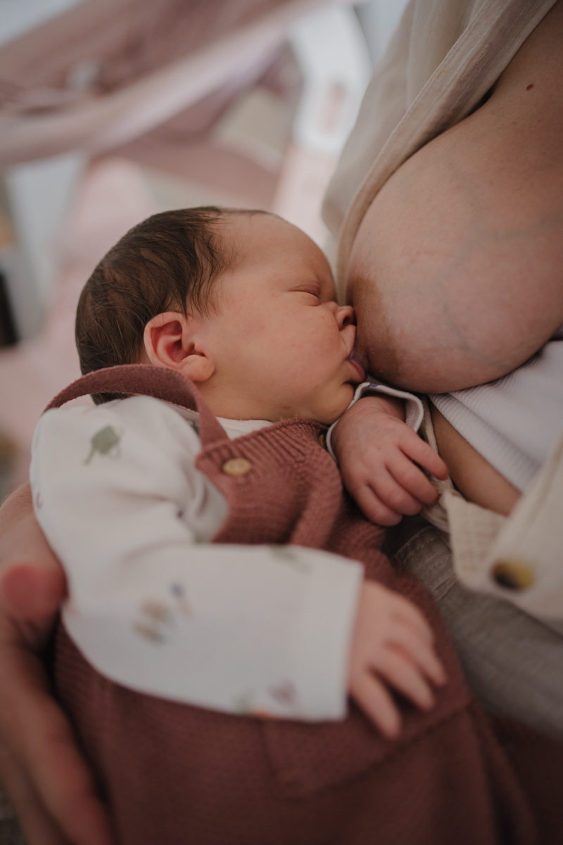 Mama stillt ihr Neugeborenes Detailaufnahme – Wochenbettfotografie in Graz und Graz Umgebung
