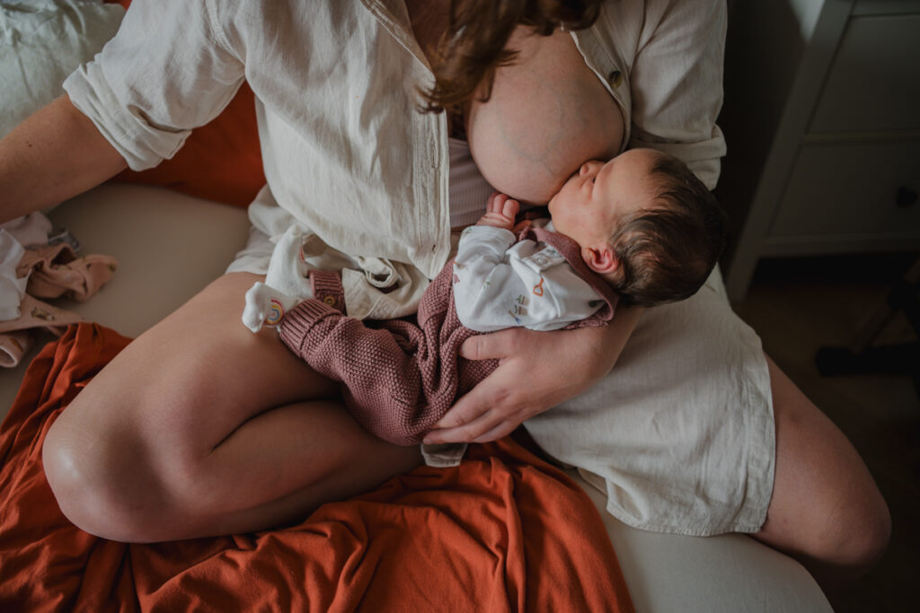 Mama stillt ihr Neugeborenes Detailaufnahme – Wochenbettfotografie in Graz und Graz Umgebung
