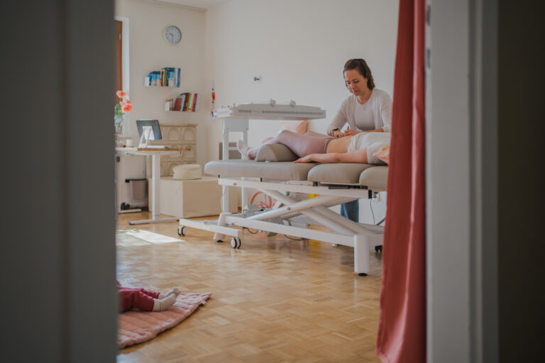 Physiotherapeutin behandelt Patientin – Businessfotografie Graz und Umgebung, authentische Arbeitsmomente in der Praxis