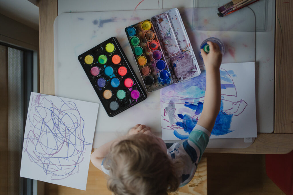 Malendes Kind mit Wasserfarben – authentischer Familienalltag, dokumentarisch fotografiert in Graz und Umgebung