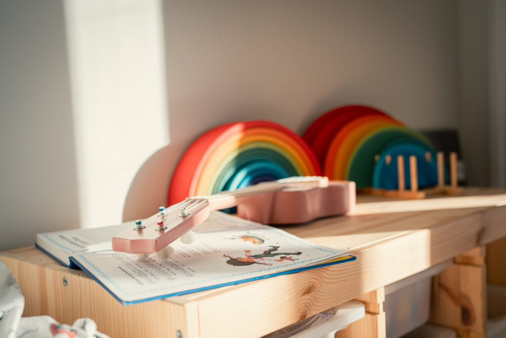 Ruhiges Detail aus einem Kinderzimmer mit Liederbuch und rosa Gitarre – ungestellte Familienfotografie in Graz und Umgebung