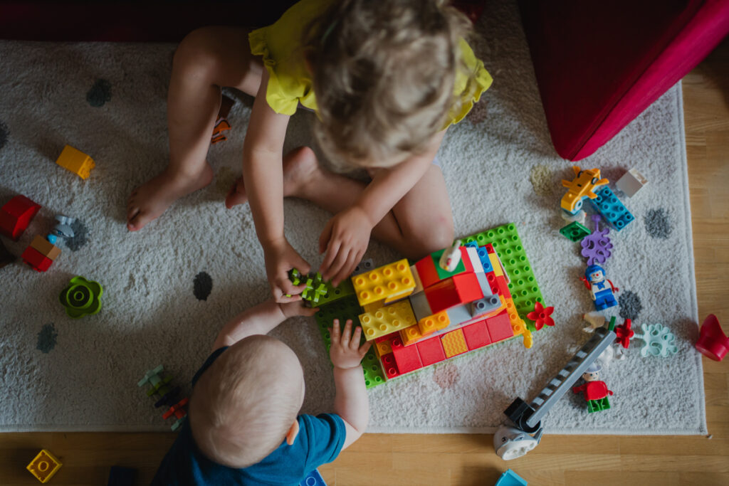 Oberansicht von zwei Kindern, die mit Duplo spielen – gemeinsamer Alltagsmoment, dokumentarische Familienfotografie in Graz und Umgebung