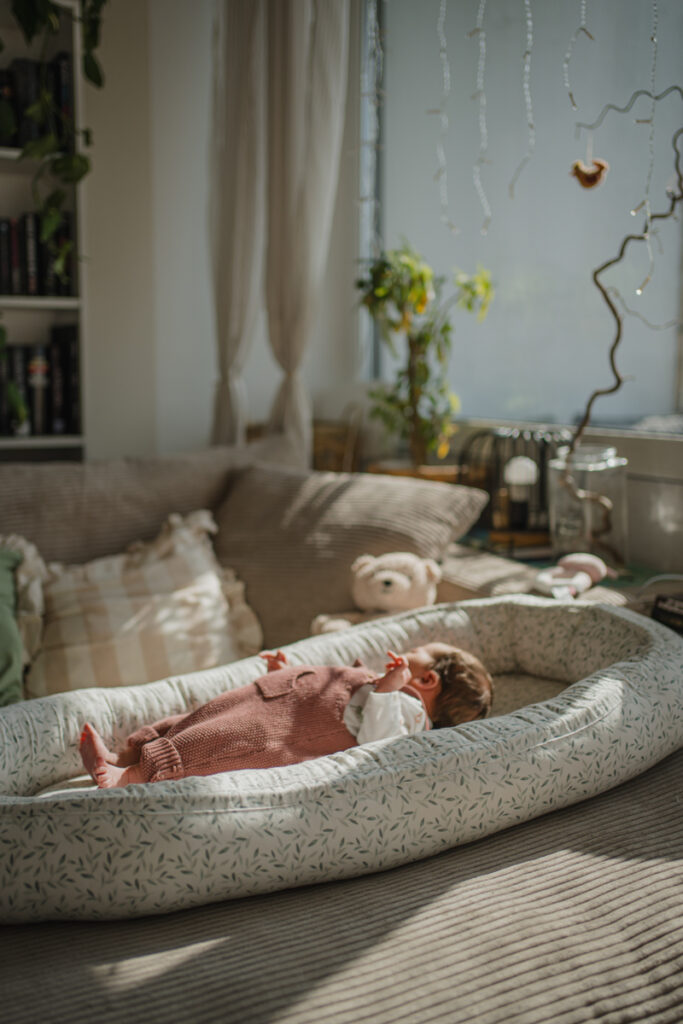 Neugeborenes im Nestchen am Sofa – ungestellter Familienalltag im Wochenbett in Graz und Umgebung
