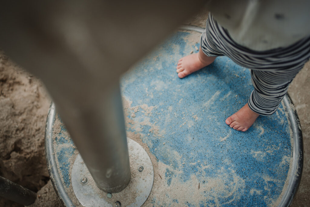 Oberansicht eines barfüßigen Kindes am Spielplatz – unbeschwerter Alltagsmoment, dokumentarische Familienfotografie in Graz und Umgebung