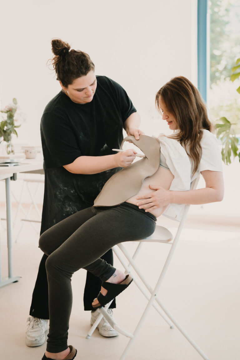 Eine Grazer Fotografin die Personal Brand Fotos anbietet begleitet eine Keramikerin aus Graz, wie sie eine Baby Belly Bowl mit einer Schwangeren Mama und deren Freundinnen anfertigt.