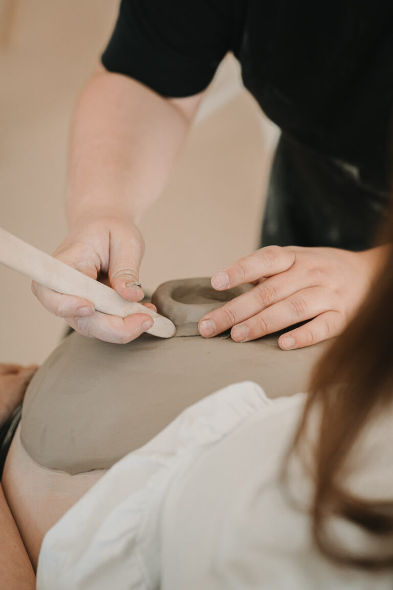 Eine Grazer Fotografin die Personal Brand Fotos anbietet begleitet eine Keramikerin aus Graz, wie sie eine Baby Belly Bowl mit einer Schwangeren Mama und deren Freundinnen anfertigt.