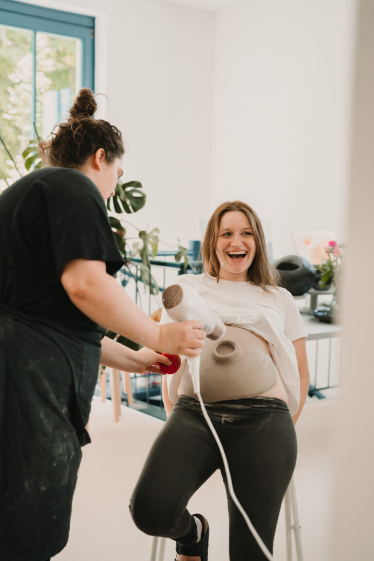 Eine Grazer Fotografin die Personal Brand Fotos anbietet begleitet eine Keramikerin aus Graz, wie sie eine Baby Belly Bowl mit einer Schwangeren Mama und deren Freundinnen anfertigt.
