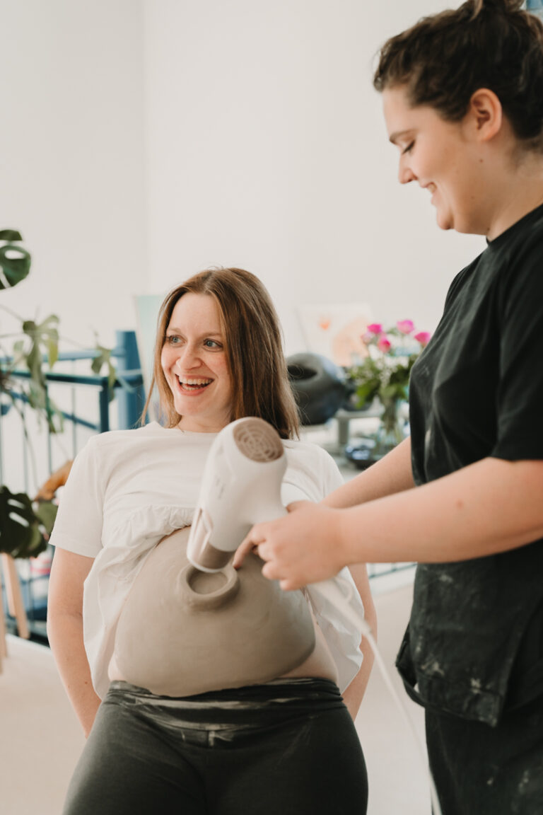 Eine Grazer Fotografin die Personal Brand Fotos anbietet begleitet eine Keramikerin aus Graz, wie sie eine Baby Belly Bowl mit einer Schwangeren Mama und deren Freundinnen anfertigt.