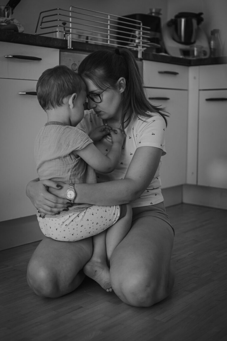 Authentische Familienfotografie in Graz – eine Mutter tröstet ihr Kind während eines dokumentarischen Familienshootings